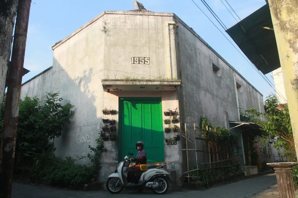 Bangunan tua bertuliskan 1935 dengan pintu hijau di gang Laweyan